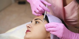 医生美容师注射肉毒杆菌毒素。收紧和抚平皱纹的程序。振兴面部注射。