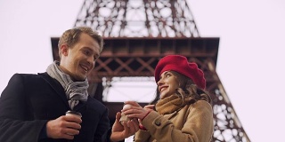 一个男人用热饮招待他的女朋友来保暖，浪漫的欧洲之旅