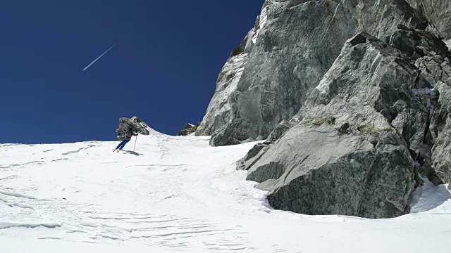 在阳光明媚的日子里，人们在雪山上免费滑雪。登山滑雪活动。滑雪者冬季在高山户外进行滑雪运动。前视图。慢动作60p 4k视频