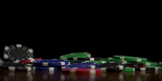 掉落的扑克筹码孤立在黑色背景上。彩色扑克筹码落在桌子上的黑色背景。玩着筹码在黑色背景中飞舞
