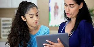 拉丁女医生拿着数字平板电脑。她正在给年轻的拉丁女病人做体育检查。
