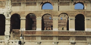 两个游客在罗马竞技场旁边，还有一个导游
