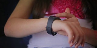 年轻的女学生在家里使用智能手表，特写