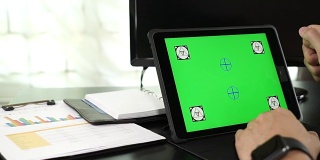 一名亚洲男子使用绿色空白屏幕的平板电脑