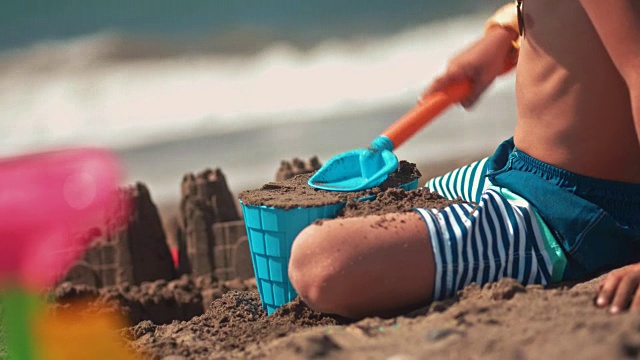 小男孩暑假在海滩上堆沙堡
