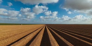 在法国诺曼底，犁沟般的农田准备种植作物和蔬菜。4K时间间隔。田园风光，春日农田。环境友好型农业和工厂化农业理念