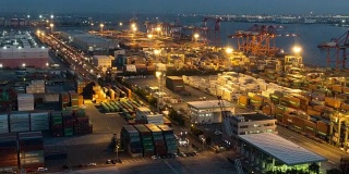白天到夜晚延时:鸟瞰图的港口工作的货物集装箱在台场日本东京