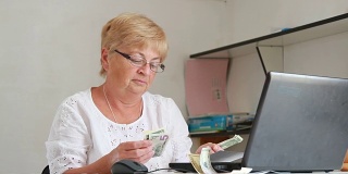 一位上了年纪的妇女拿出现金去付账单
