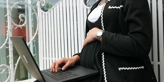 亚洲商业怀孕的网上工作与笔记本电脑