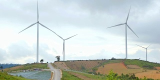 美丽的风力涡轮机与农业领域。农村玉米田可再生能源生产的概念