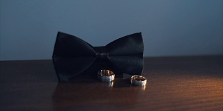 两个结婚戒指滚动到男人的黑色领结