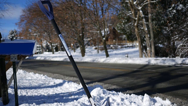 雪铲埋在雪堤附近的居民冬季路