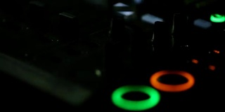 音频控制面板的特写在音乐会期间的表演。按钮被不同的颜色点亮