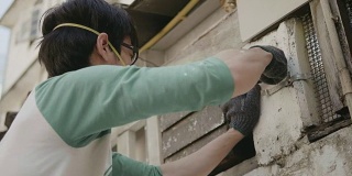 DIY亚洲男人安装排气扇。