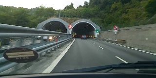 许多汽车在城外的高速公路上行驶，绕过黑暗的隧道