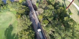 无人机俯瞰铁路轨道和火车穿过德克萨斯州奥斯汀镇湖大桥