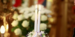 在教堂里，新娘和新郎手持蜡烛举行婚礼