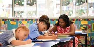 在教室里帮助孩子们做作业的土著教师