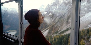 从缆车上看阿尔卑斯山湖的风景的女人