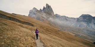 在Dolomites的Seceda山附近徒步旅行的妇女