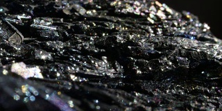 MACRO:黑色赤铁矿，玻璃般的表面闪烁着各种颜色。