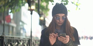 年轻女子在街上使用手机