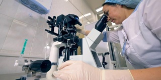 校准显微镜的实验室工作人员的低视角。