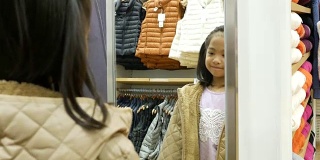 亚洲女孩有乐趣试穿布在镜子前