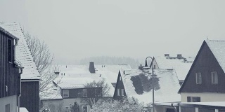 家庭房屋的积雪屋顶。山城街道、村雪灾。