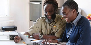加勒比黑人夫妇在家里用笔记本电脑处理家庭财务