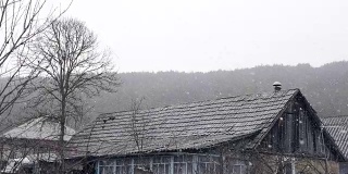 美丽的冬村背景。大雪打在乡村建筑的屋顶上。森林自然。浪漫的仙境。环境优美