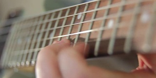 近距离的手指拨动吉他的和弦