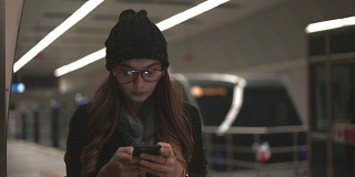 一位年轻女士在地铁里用手机