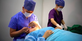 4K:医生在现代手术室为病人准备手术的肖像。