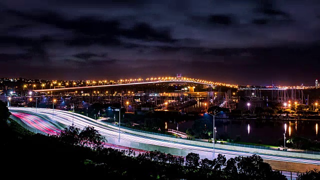 在海上亮着灯的桥和高速公路上行驶的汽车的时间流逝