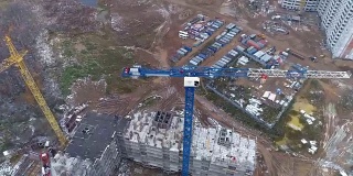 一架摄像机围绕着建筑工地的蓝色塔吊旋转。