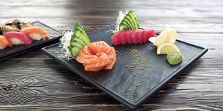 手握寿司和生鱼片，木桌。
