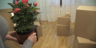 一个年轻的女孩拿着花在一间新公寓里