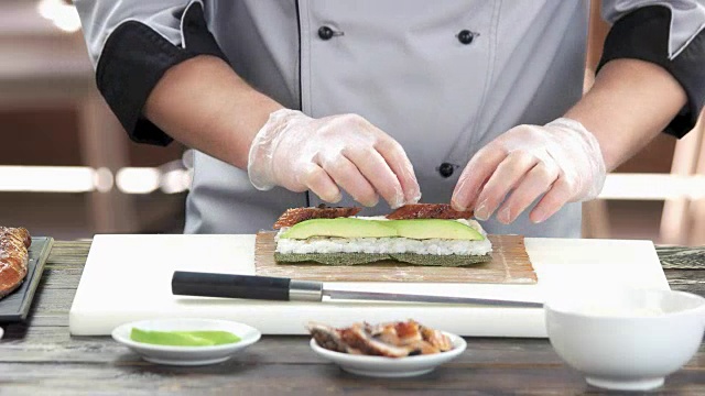 厨师在做鳗鱼寿司卷。