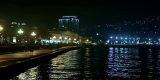 晚上，人们走在克里米亚黑海的长廊上