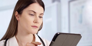 专业女医生用听诊器在病房使用平板。在职女医生