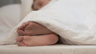 女性在白毯子下挠脚，过敏需要治疗视频素材模板下载