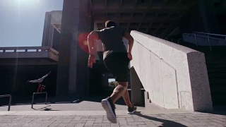在城市空间里进行跑酷的自由跑步者视频素材模板下载