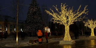 在镇中心的主要街道上，人们走过和路过圣诞树灯和心情。时间流逝