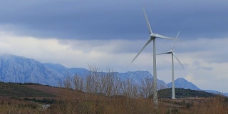 风力涡轮机与戏剧性的天空背景在比利牛斯东方