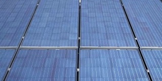 在阳光明媚的一天，屋顶上的光伏太阳能电池在太阳能板上滑行，产生清洁的可再生能源