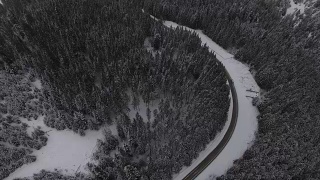 汽车行驶在雪地里的乡村道路上，无人机鸟瞰图视频素材模板下载
