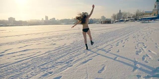 一个穿着比基尼的长发女人在雪地上跳跃。