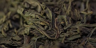茶药材质地。绿茶。有机干绿茶叶。一堆干绿茶的背景。宏