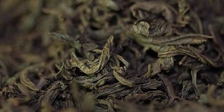 茶药材质地。绿茶。有机干绿茶叶。一堆干绿茶的背景。宏